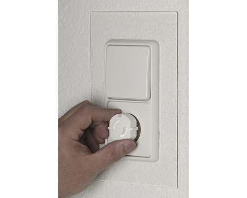 Hand plaatst kinderbeveiliging in stopcontact