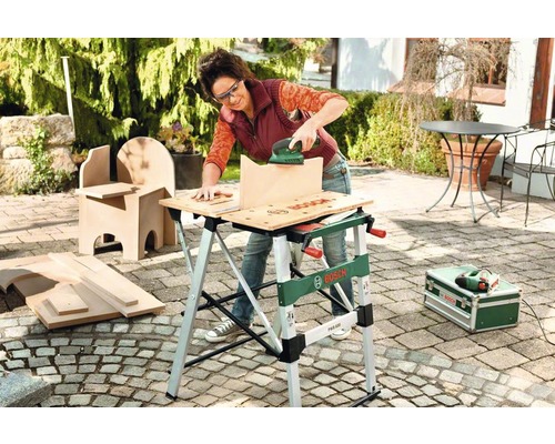 Vrouw schuurt een stuk hout met een schuurmachine op een Bosch werkbank
