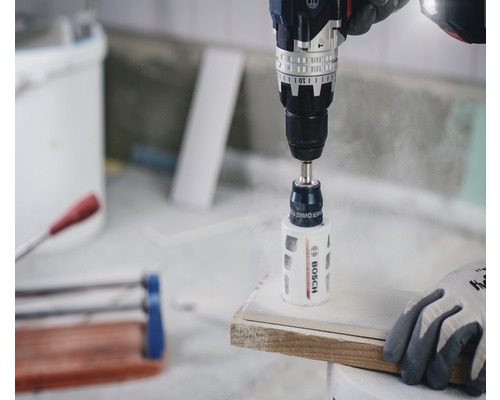 Boormachine met gatzagen boort in een werkstuk.