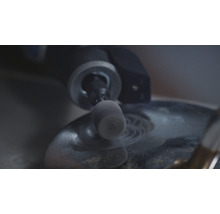 Close-up van een slijpmachine die op een oppervlak werkt