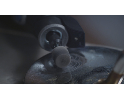 Close-up van een slijpmachine die op een oppervlak werkt