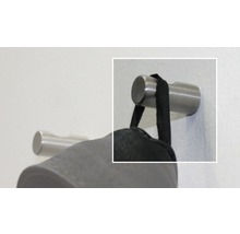 Metalen kledinghaak aan de muur met hangend kledingstuk