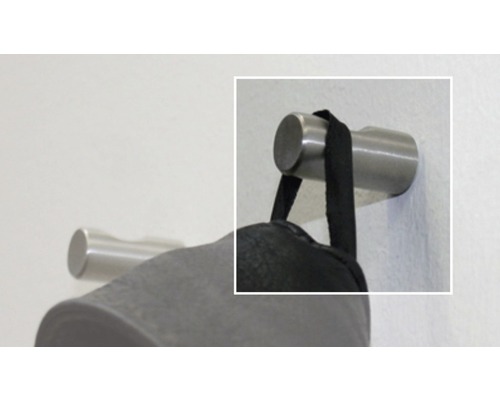 Metalen kledinghaak aan de muur met hangend kledingstuk