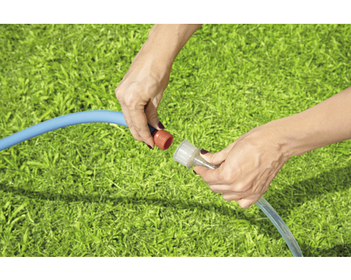 Vrouw verbindt tuinslang met snelkoppeling op gazon