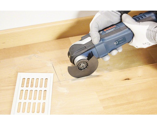 Vloerfrees in gebruik voor het zagen van een houten vloer met een ventilatierooster