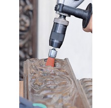 Boormachine met borstelopzetstuk reinigt een houten ornament