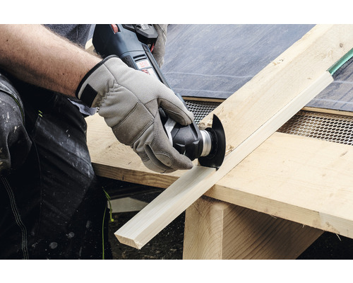 Een persoon zaagt een houten plank met een multifunctioneel gereedschap.