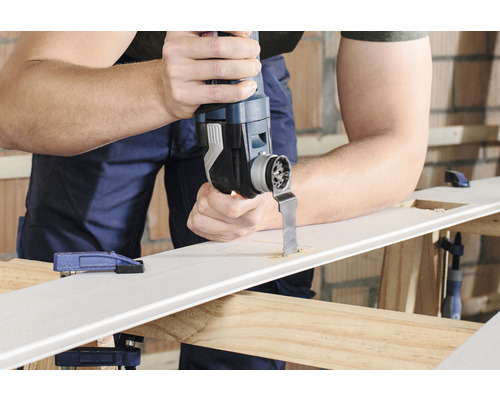 Man snijdt met een multifunctioneel gereedschap een gat in een werkstuk