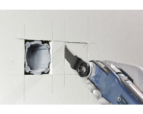 Oscillerend elektrisch gereedschap snijdt een opening in een wand voor een inbouwdoos