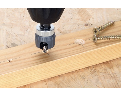 Verzinkboor in gebruik op een houten plank naast schroeven