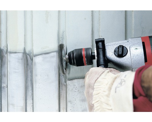 Persoon gebruikt een boormachine met een staalborstel om een metalen oppervlak te reinigen