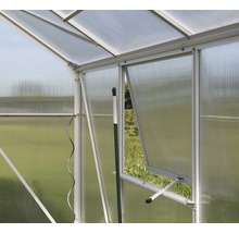 Detailopname van een kas met open raam voor ventilatie.