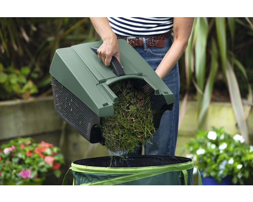 Tuinier leegt grasresten in een tuinzak