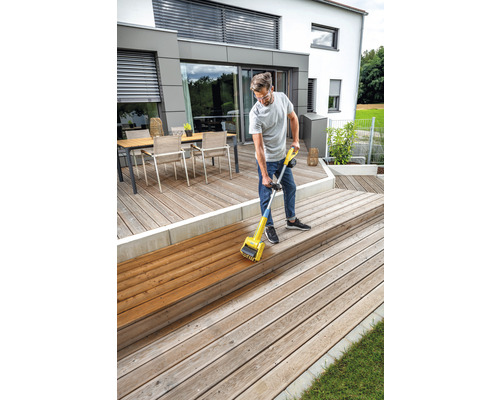 Man behandelt houten terras met een houtolieapparaat