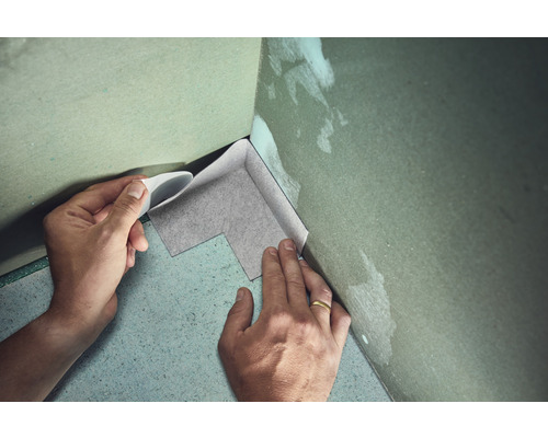 Persoon brengt afdichtband aan in een hoek