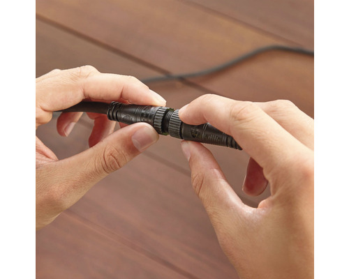 Twee handen verbinden een kabel