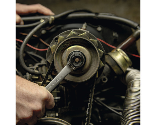 Een 19 millimeter moersleutel wordt gebruikt op een automotor.