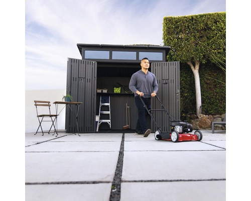 Scene met grasmaaier voor open tuinhuis, ladder en tuinmeubelen