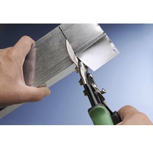 Plaatwerkschaar knipt een metalen profiel.