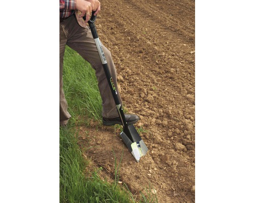 Een persoon gebruikt een spade in de tuin.