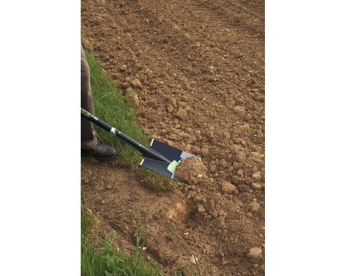 Iemand graaft met een spade in een veld.