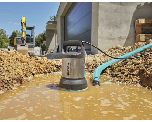 Tuindompelwaterpomp in gebruik op een bouwplaats met graafmachine