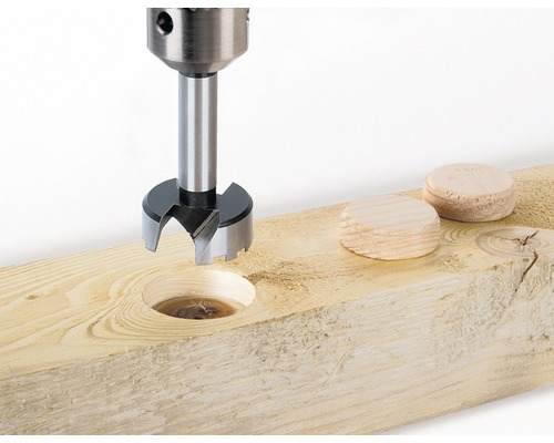 Forstnerboor in gebruik op een houten plank met houten pluggen