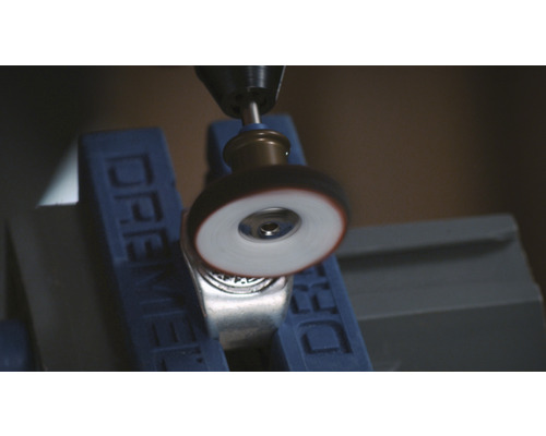 Dremel gereedschap polijst een metalen ring in een bankschroef