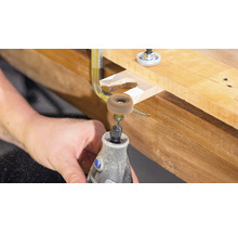 Dremel gereedschap tijdens het bewerken van een stuk hout met een schuurschijf.