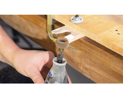 Dremel gereedschap tijdens het bewerken van een stuk hout met een schuurschijf.