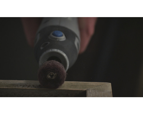 Een multifunctioneel gereedschap schuurt een stuk hout.