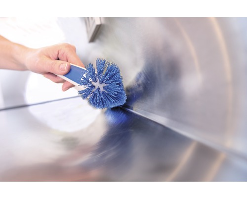 Hand reinigt wastafel met borstel