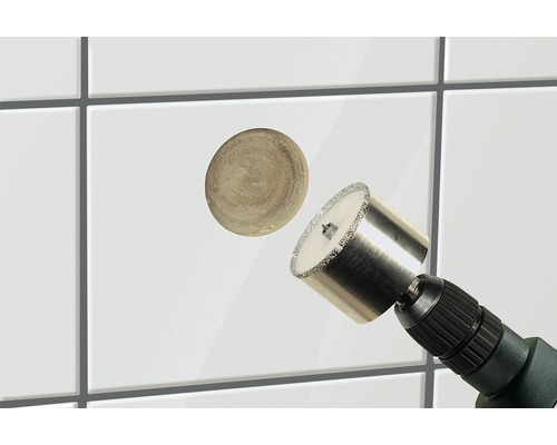 Tegelboor in gebruik op witte tegels