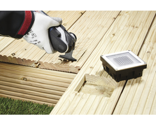 Installatie van een terraslamp met multifunctioneel gereedschap op een houten terras