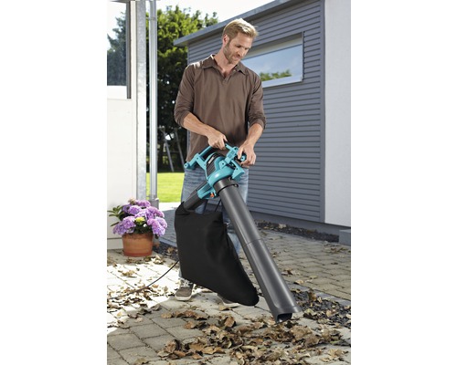 Man gebruikt een bladblazer in de tuin.