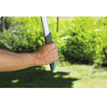 Hand houdt tuingereedschap met handvat in de tuin vast