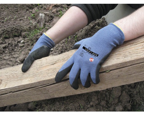 Handen met tuinhandschoenen houden een houten plank vast