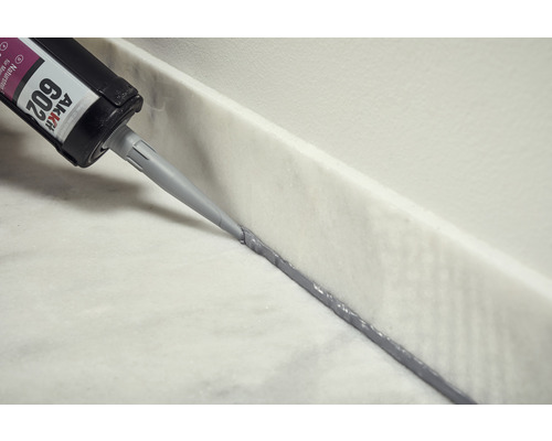 Aanbrengen van natuursteen siliconen met een patroon op een marmeren oppervlak.