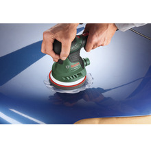 Een persoon schuurt een blauwe auto met een excentrische schuurmachine van Bosch.