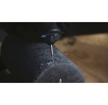 Close-up van een graveermachine die een patroon in een donkere kaars snijdt
