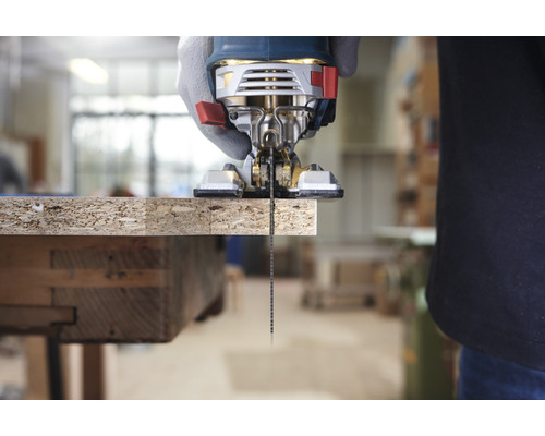 Een decoupeerzaag zaagt een houten plank.