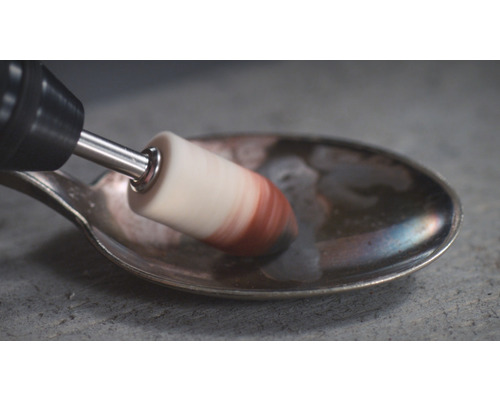 Een roterende borstel polijst een lepel.