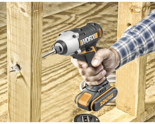 Iemand gebruikt een Worx accuslagschroevendraaier om een gat in een stuk hout te boren.