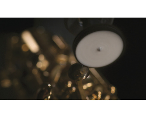 Gedetailleerde opname van een gouden saxofoon met witte pads en kleppen