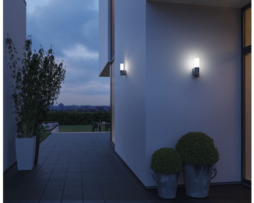 Buitenshuis met twee wandlampen en planten