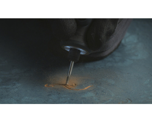 Iemand graveert met een multifunctioneel gereedschap in een materiaal.