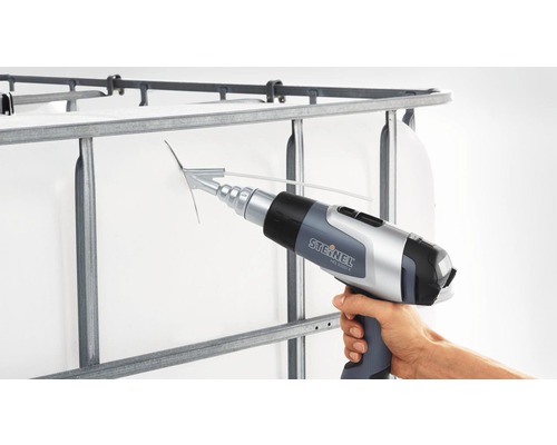 Een hand houdt een Steinel heteluchtpistool vast bij het raster van een Intermediate Bulk Container.