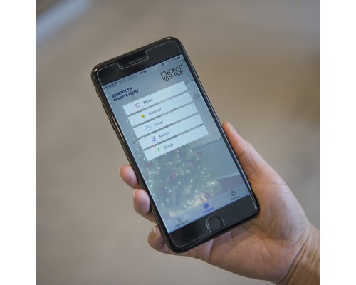 Smartphone met weergave van de app voor het bedienen van kerstverlichting