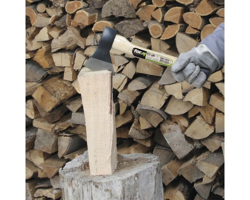Bijl splijt blok hout voor een stapel hout