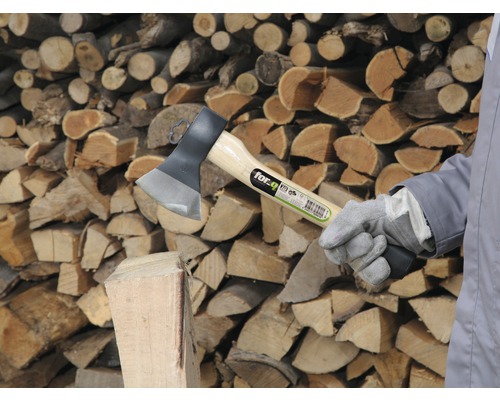 Kloofbijl met houten stam en stapel hout op de achtergrond